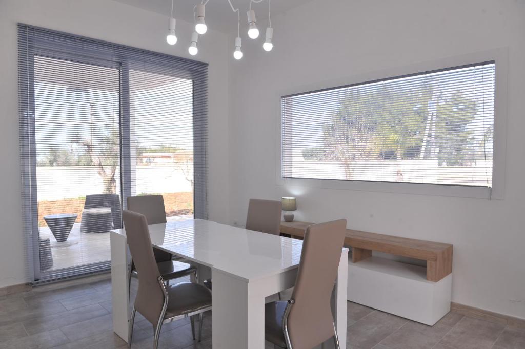 ein Esszimmer mit einem weißen Tisch und Stühlen in der Unterkunft Villa Rachele in Sant'Isidoro