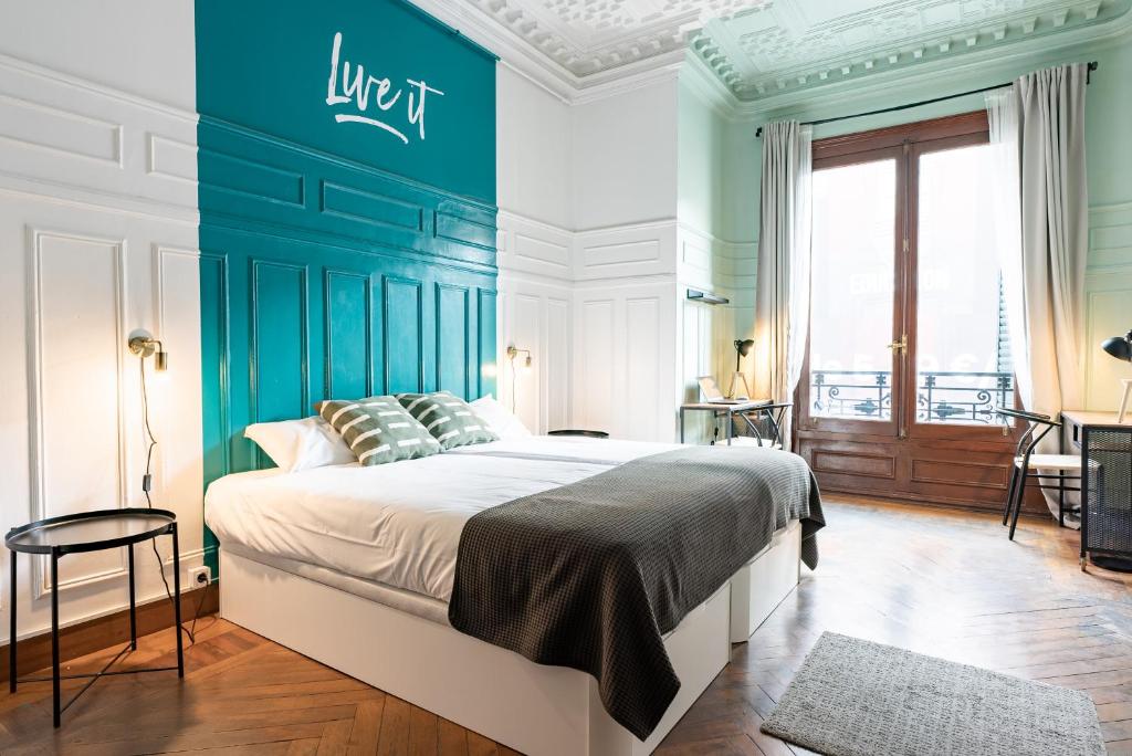 1 dormitorio con 1 cama grande y pared azul en Live it Madrid Gran Vía, en Madrid