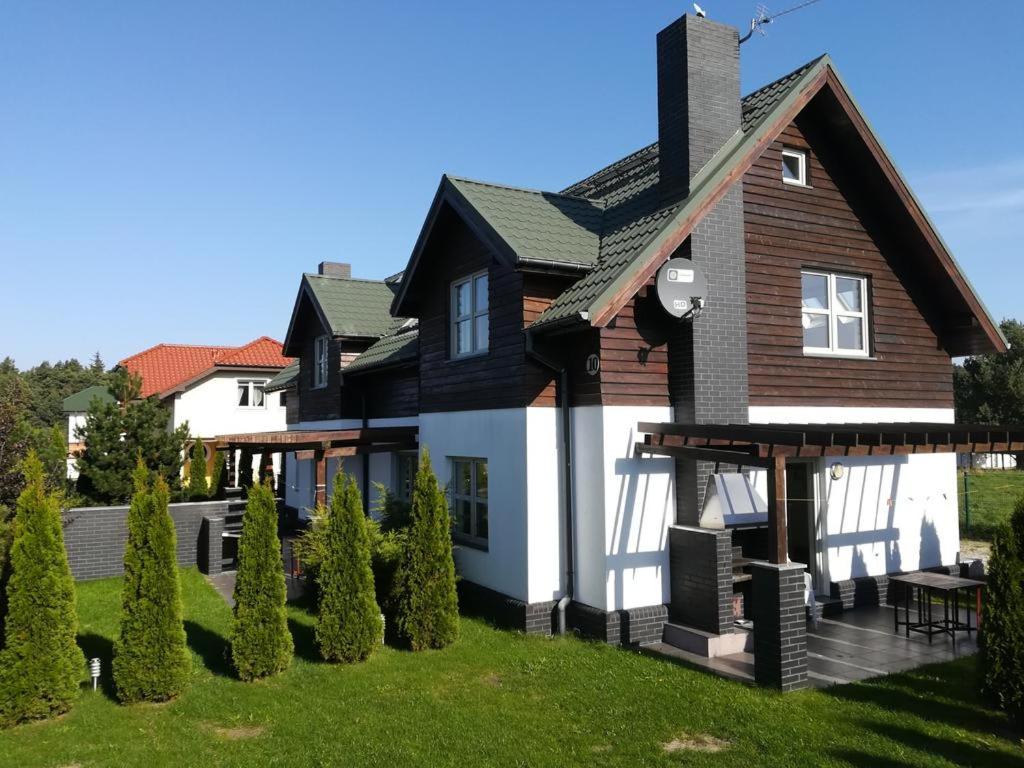 a black and white house with a lawn at GRIBKO SEASIDE APARTMENTS in Grzybowo