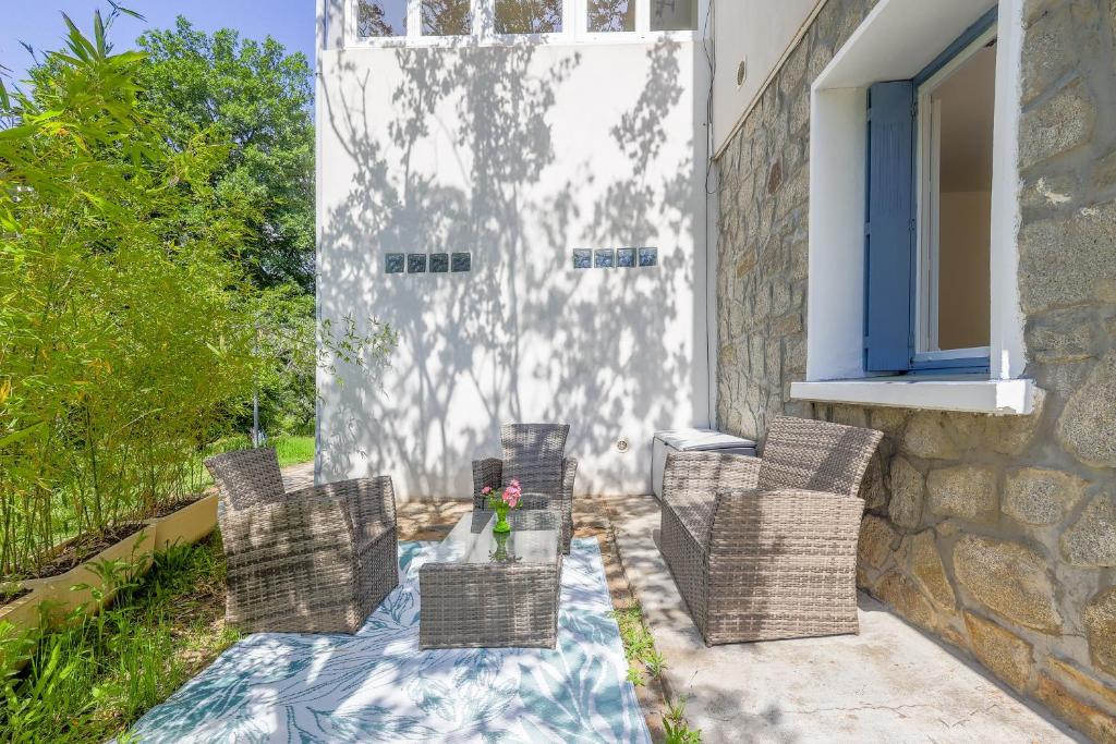 eine Terrasse mit Stühlen und einem Tisch vor einem Gebäude in der Unterkunft Terrazza Moriani - Charmant appartement à 500m de la mer in San-Nicolao