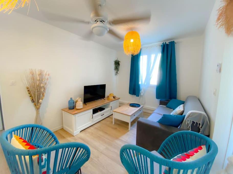 Una sala de estar con sillas azules y un sofá. en L'Azur, en Saint-Pierre
