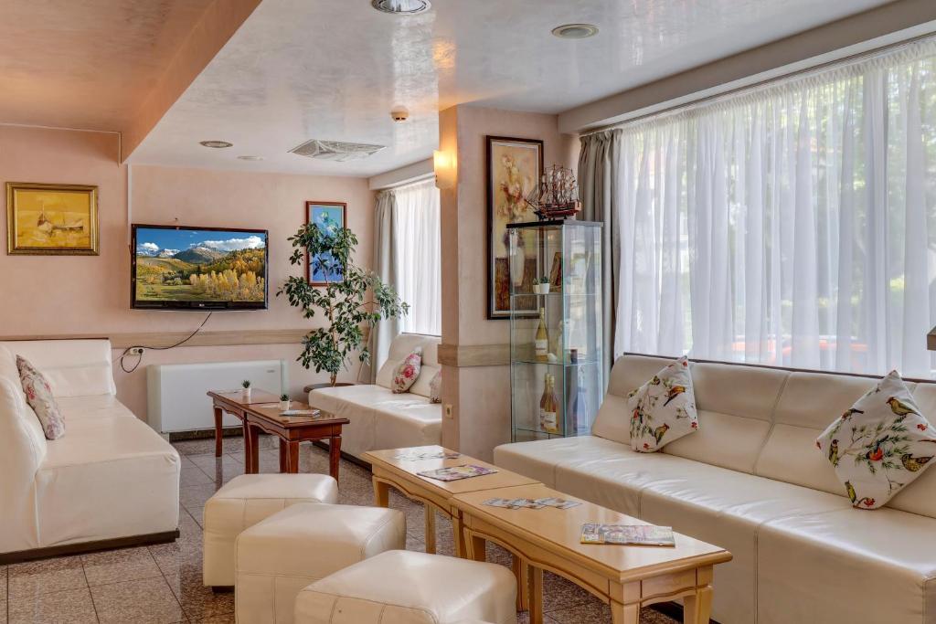 a living room with white furniture and a large window at Paraiso Theopolis - All Inclusive in Obzor
