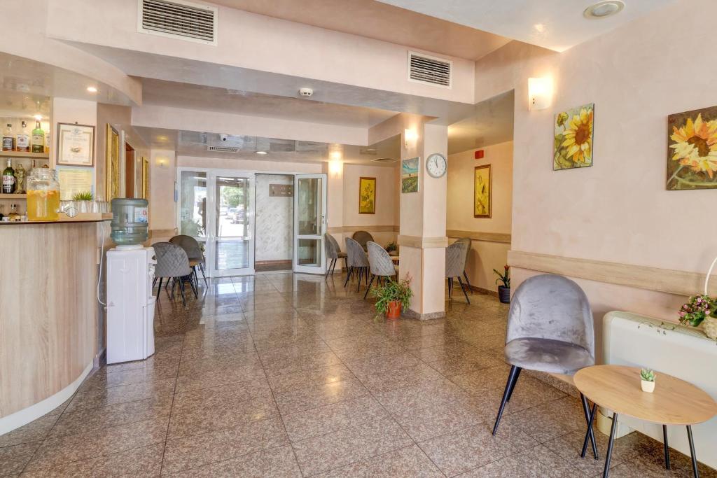 a large room with tables and chairs and a kitchen at Paraiso Theopolis - All Inclusive in Obzor