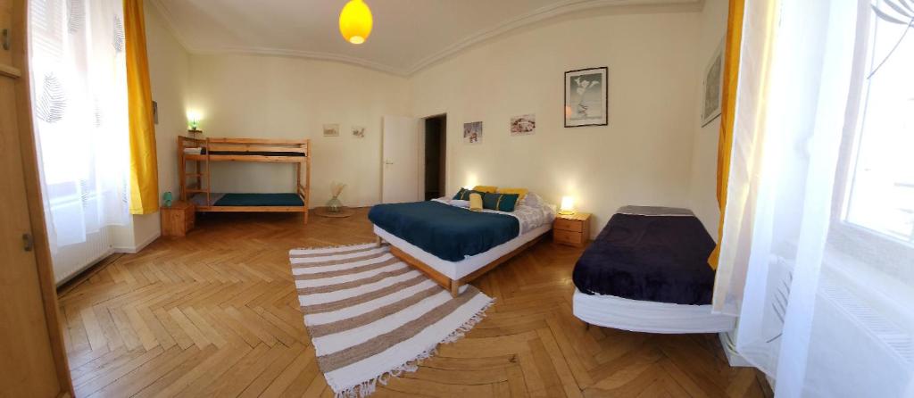 um quarto com 2 camas e um tapete em Gite Jonquille 2 à 8 personnes avec SPA em Ventron