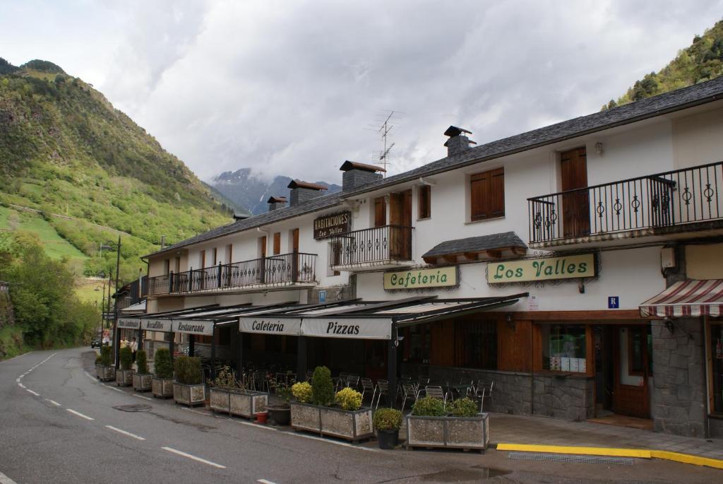 a building on the side of a road next to a mountain at Hostal Los Valles in Bielsa