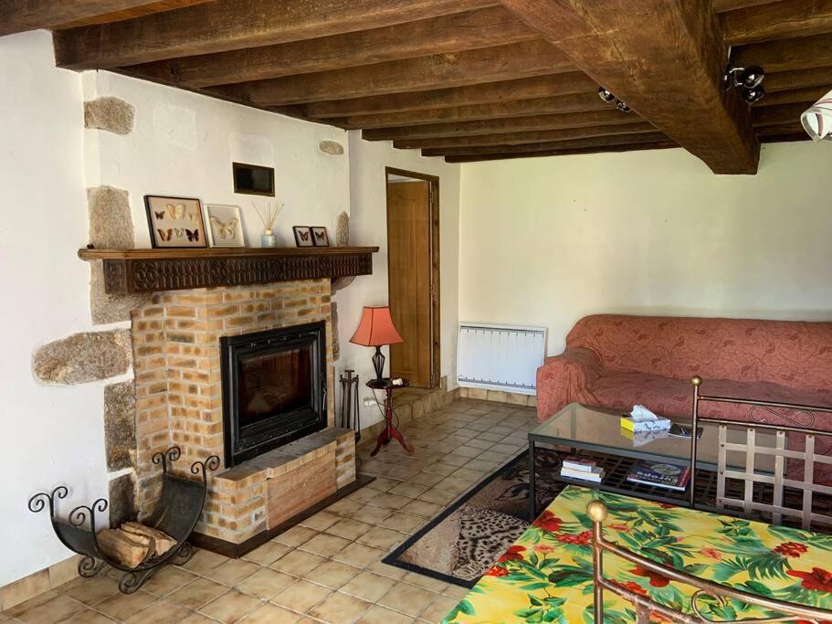 a living room with a couch and a fireplace at Chez Milo, rural cottage in Roches