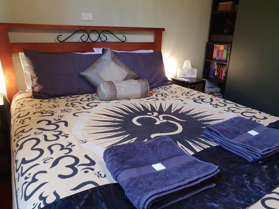 Un dormitorio con una cama con toallas moradas. en No no no no, en Melbourne