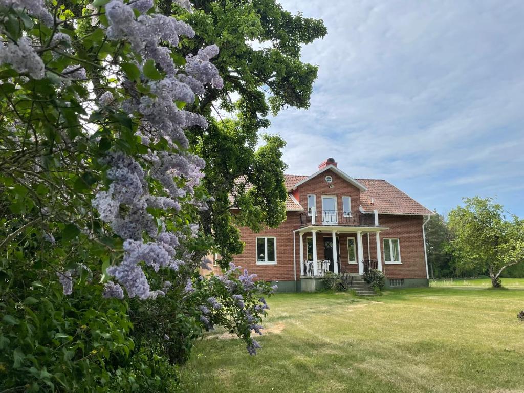 una gran casa de ladrillo con un árbol delante en Villa Walterängen, en Tibro