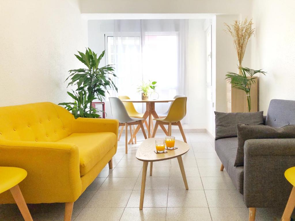 a living room with a yellow couch and a table at Bonito apartamento en Castellón in Castellón de la Plana