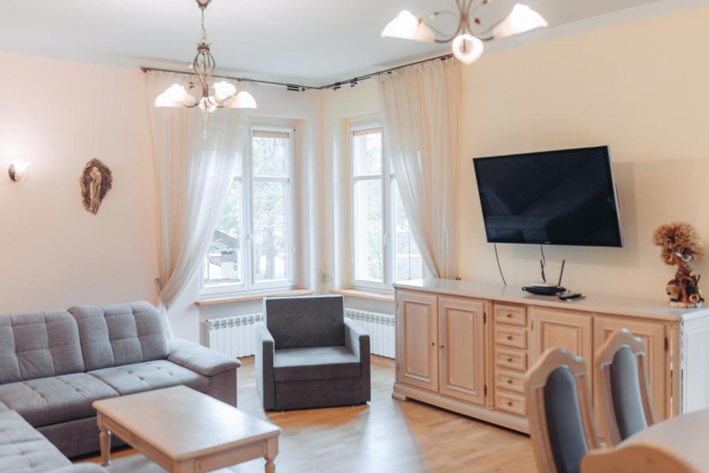 Televízia a/alebo spoločenská miestnosť v ubytovaní Apartament Mazurek