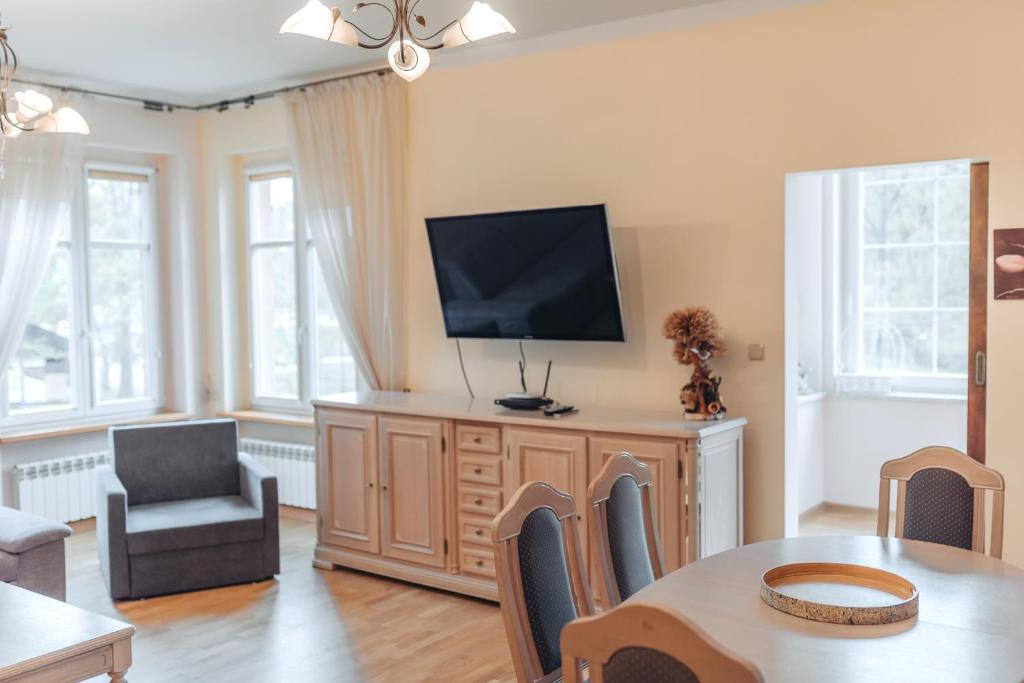 Televízia a/alebo spoločenská miestnosť v ubytovaní Apartament Mazurek