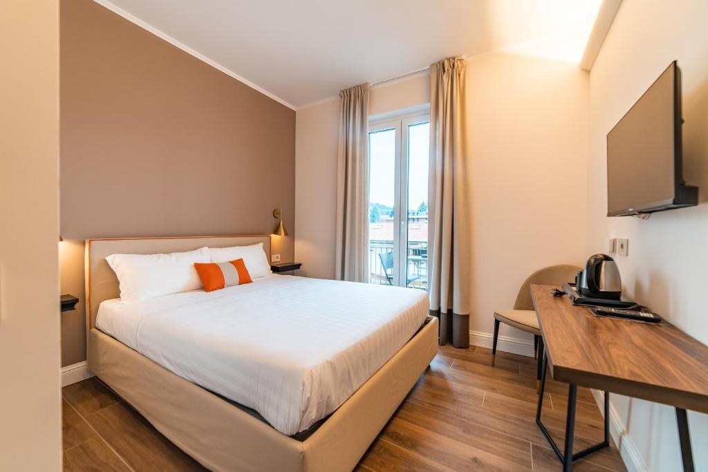 ein Hotelzimmer mit einem Bett und einem TV in der Unterkunft Hotel del Conte in Laveno
