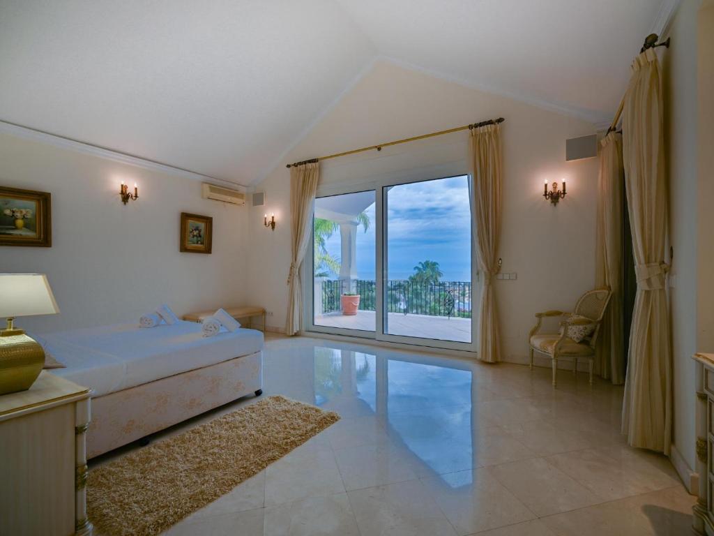 sypialnia z łóżkiem i dużym oknem w obiekcie El Rosario large villa w heated pool w Marbelli