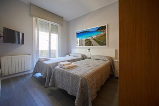 a bedroom with two beds and a television in it at Calvario 4 in Vigo