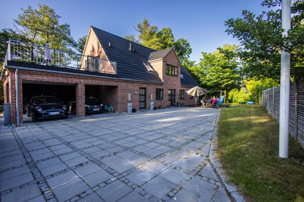 a brick house with a balcony on top of it at Lake House Central Lyngby in Kongens Lyngby