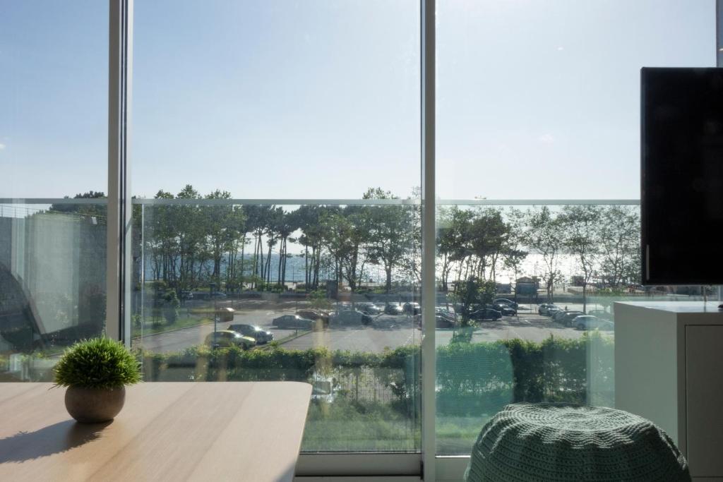 ein großes Fenster mit Blick auf einen Parkplatz in der Unterkunft Apartamentos Dunas de Samil in Vigo
