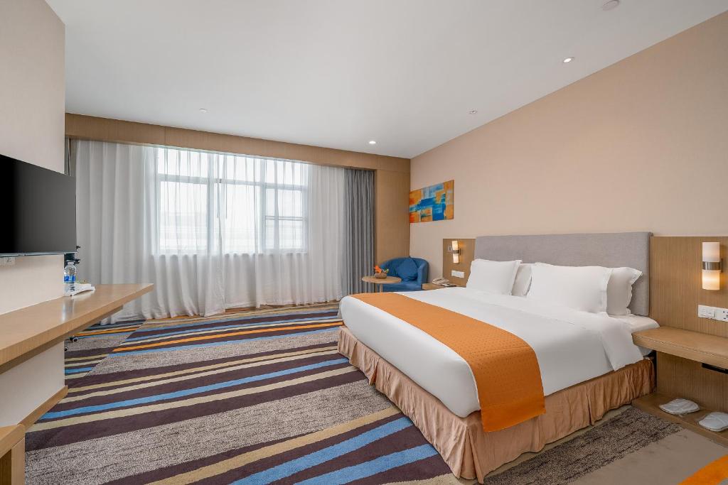 Postel nebo postele na pokoji v ubytování Guangzhou Baiyun Airport Rejoice by Argyle Hotel Rehe Metro Exit B --Free shuttle bus is provided during the 137th Canton Fair
