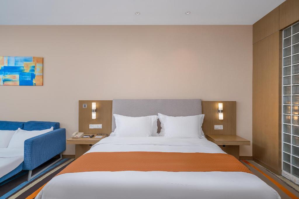 Postel nebo postele na pokoji v ubytování Guangzhou Baiyun Airport Rejoice by Argyle Hotel Rehe Metro Exit B --Free shuttle bus is provided during the 137th Canton Fair