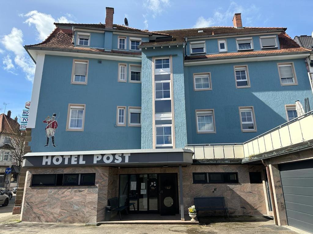 duży niebieski budynek z znakiem pocztowym hotelu w obiekcie Hotel Post w mieście Mühlacker