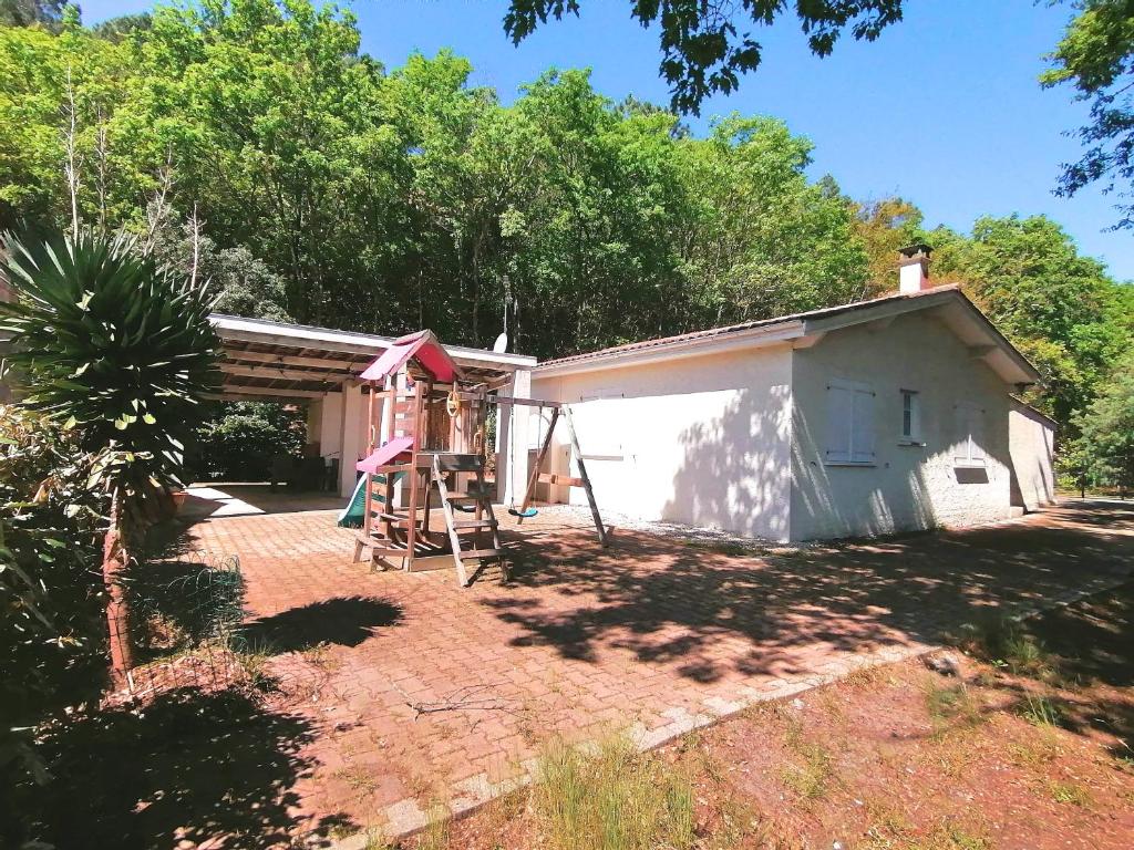 une maison avec une échelle à côté d'un bâtiment dans l'établissement Maison chaleureuse et spacieuse, à Lacanau