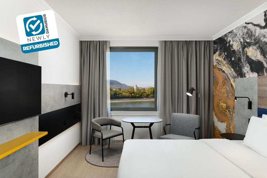 a hotel room with a bed and a table and a window at Danubius Hotel Helia in Budapest