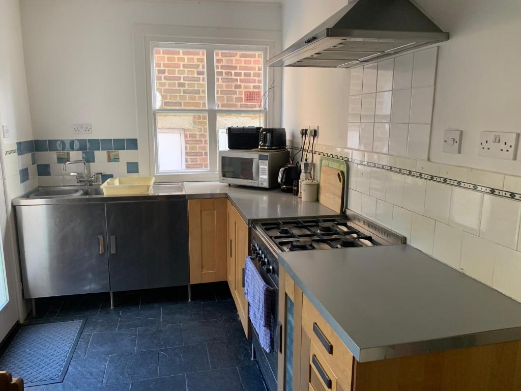 a kitchen with a sink and a stove top oven at Vine Cottage - Sandgate in Sandgate