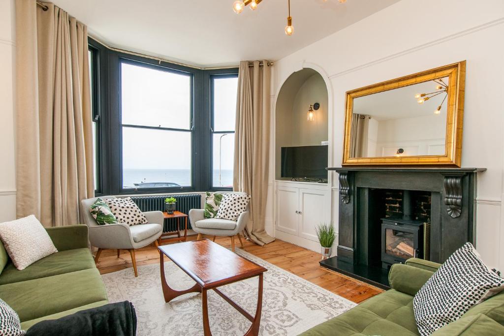 a living room with a fireplace and a mirror at King Palm Apartment at Sea View Terrace, Margate. in Kent