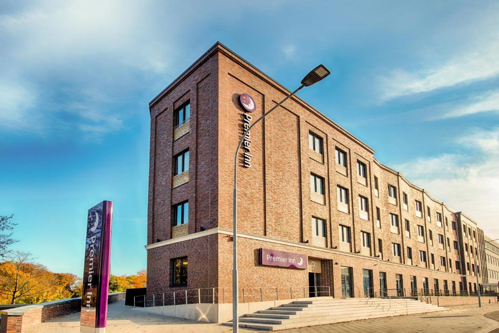 ein Backsteingebäude mit Straßenbeleuchtung davor in der Unterkunft Premier Inn Lübeck City Stadtgraben in Lübeck