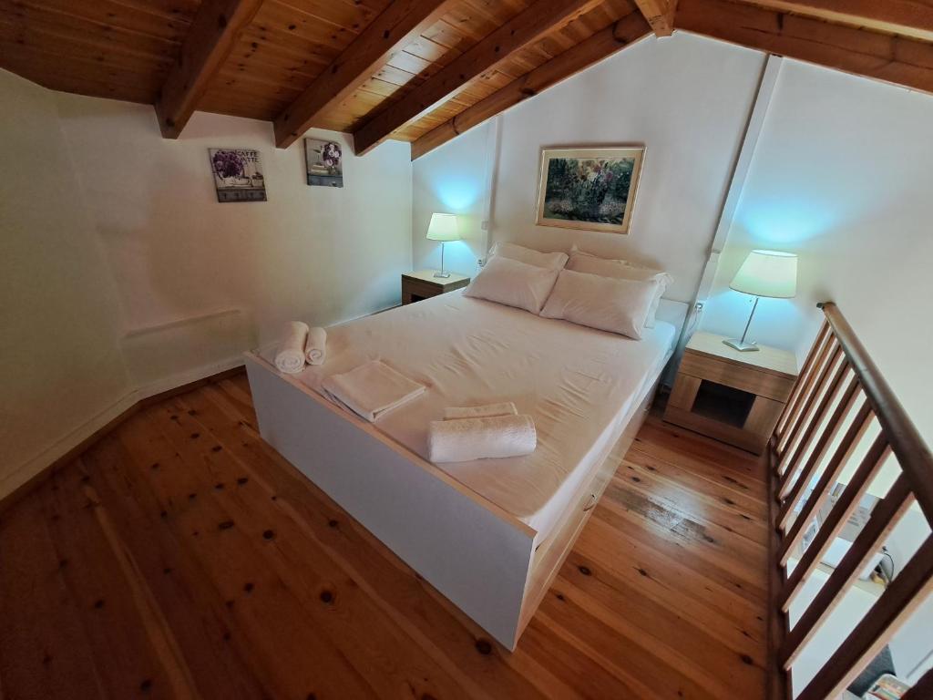 1 dormitorio con 1 cama blanca y 2 lámparas en Oceanides Apartments, en Kourouta