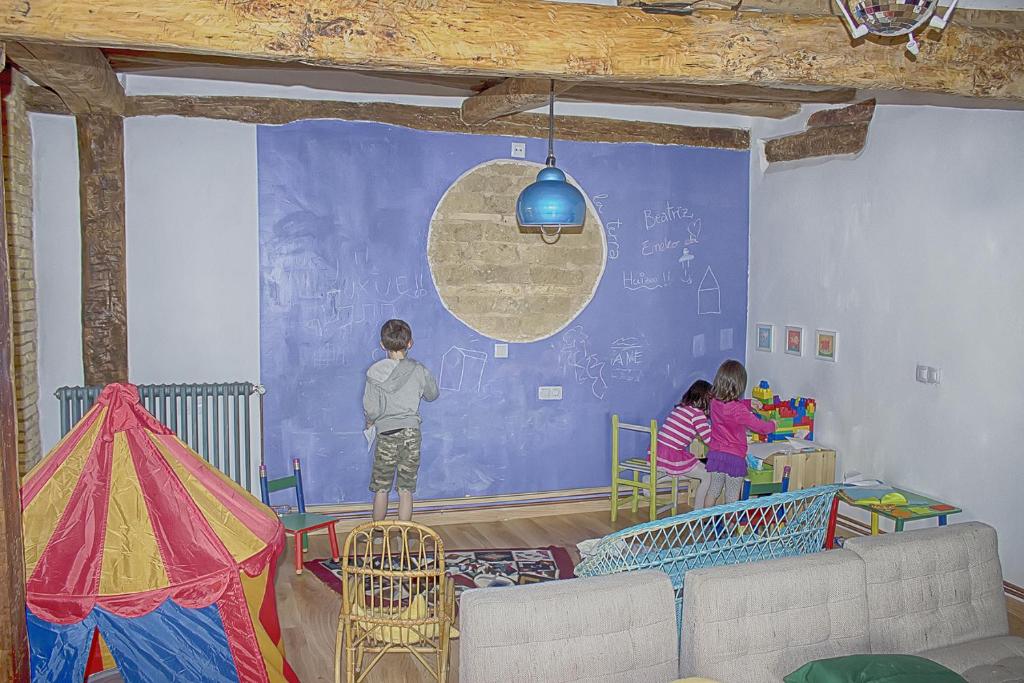 un grupo de niños en una habitación con una pared azul en La Madriguera de Tomaso, en Eraul