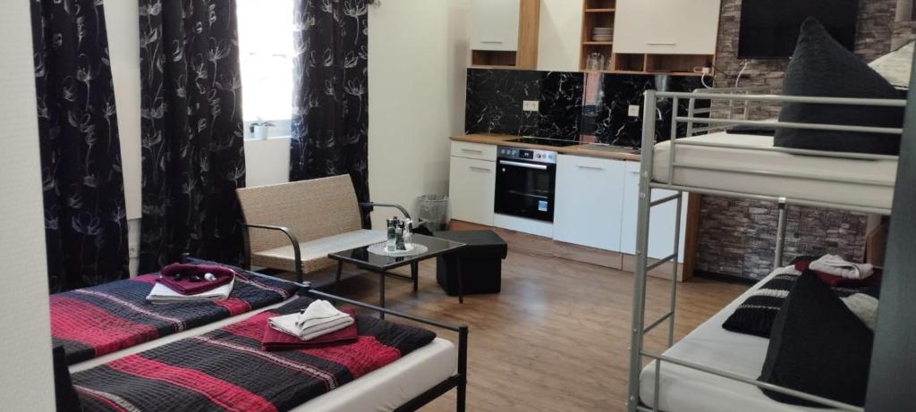 ein Wohnzimmer mit einem Etagenbett und eine Küche in der Unterkunft Zum Ewigen Rath in Mühlhausen