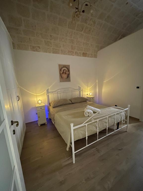 una camera con un letto bianco e due comodini di Casapulia a Fasano