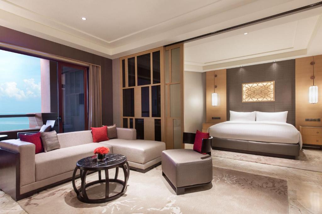 a hotel room with a bed and a couch at Haikou Marriott Hotel in Haikou