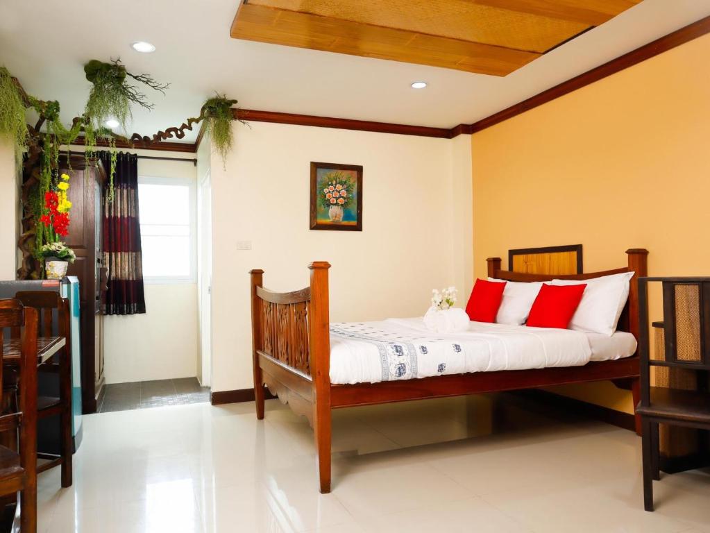 a bedroom with a bed with red and white pillows at AIRBEST Explore Chiang Rai Hotel in Chiang Rai