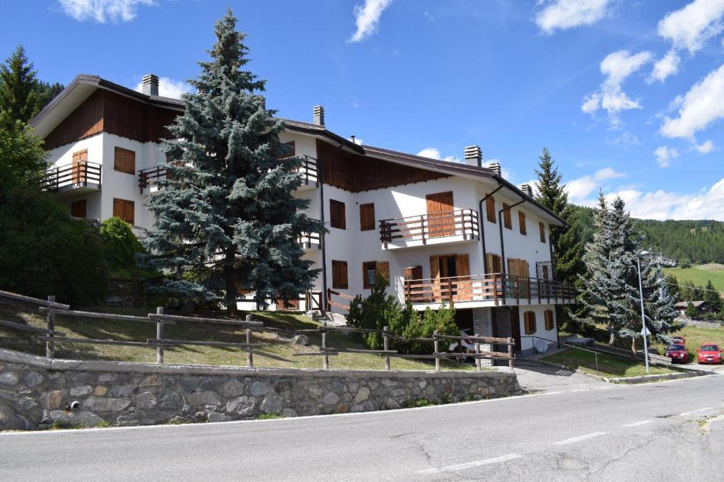 a large white building on a hill with a road at Appartamento panoramico La Chapelle in Torgnon