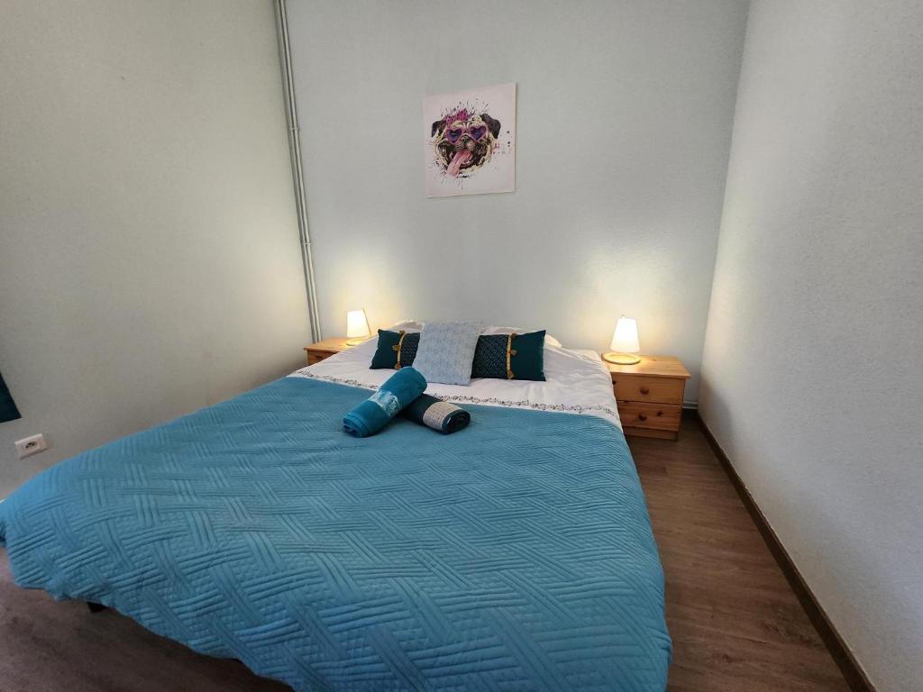 a bedroom with a blue bed with two pillows at Gite Fougère 2 à 6 personnes avec SPA in Ventron