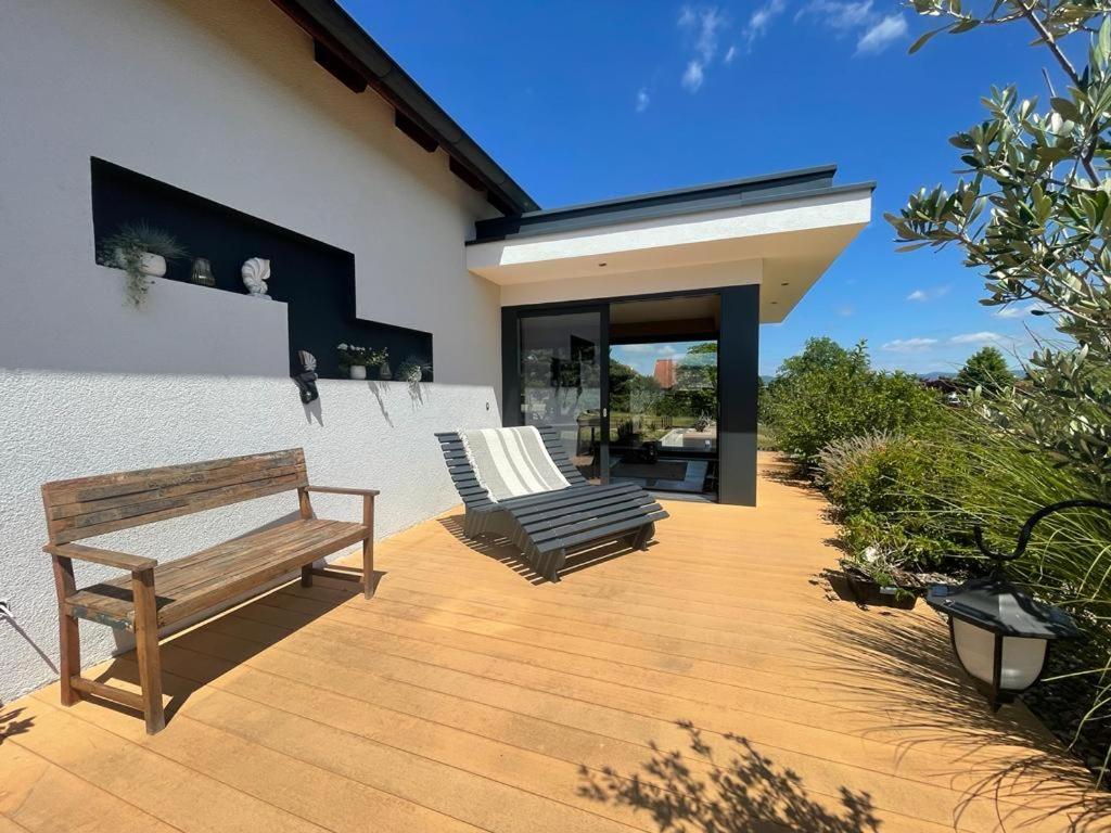 een houten terras met 2 stoelen en een bank bij Einzigartiges Haus mit Pool großem Garten und Kamin in Bad Salzungen