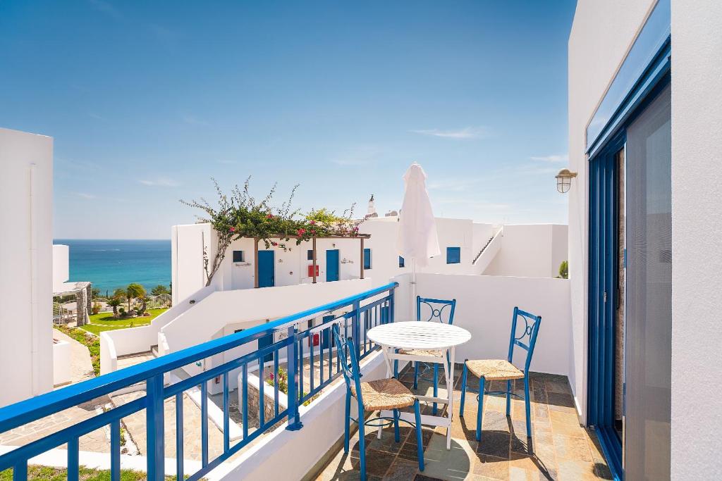 a balcony with a table and chairs and the ocean at Junior Traditional Suite in Archangelos