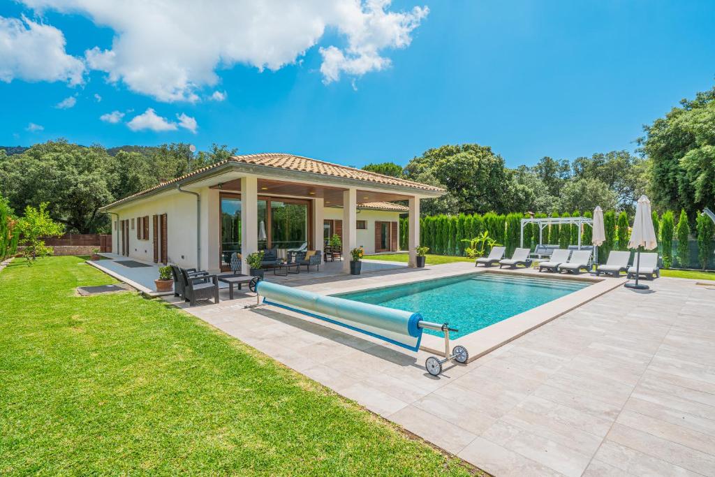 - une piscine dans une arrière-cour avec une maison dans l'établissement Villa Sa Olivera, à Crestatx