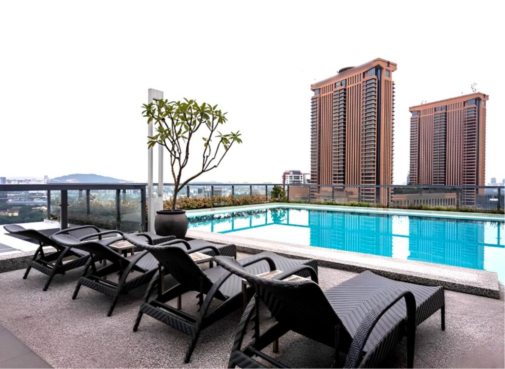 a hotel patio with chairs and a swimming pool at D'CASA Bintang Fairlane at Bukit Bintang in Kuala Lumpur