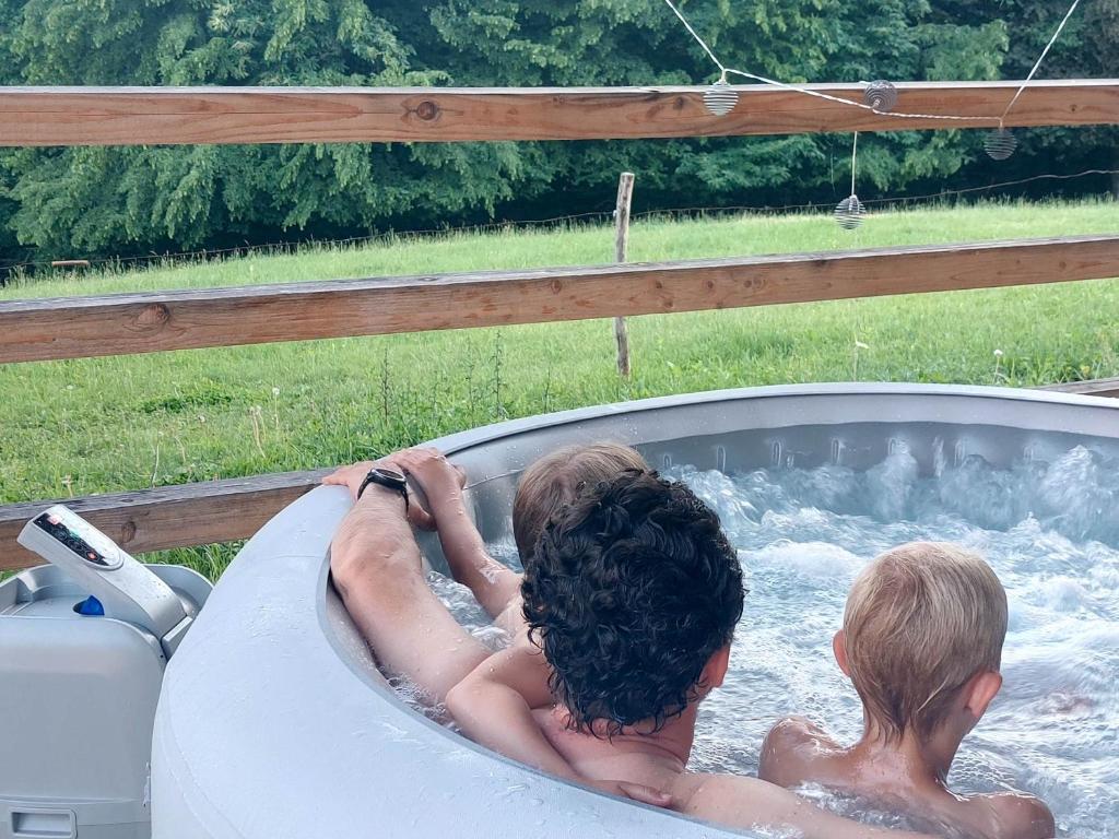 two children in a hot tub in a backyard at Glamping - Hayrack Vesel in Trebnje