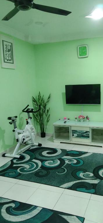 un soggiorno con TV e tappeto di Homestay Merbau Bandar Putra Kulai a Kulai