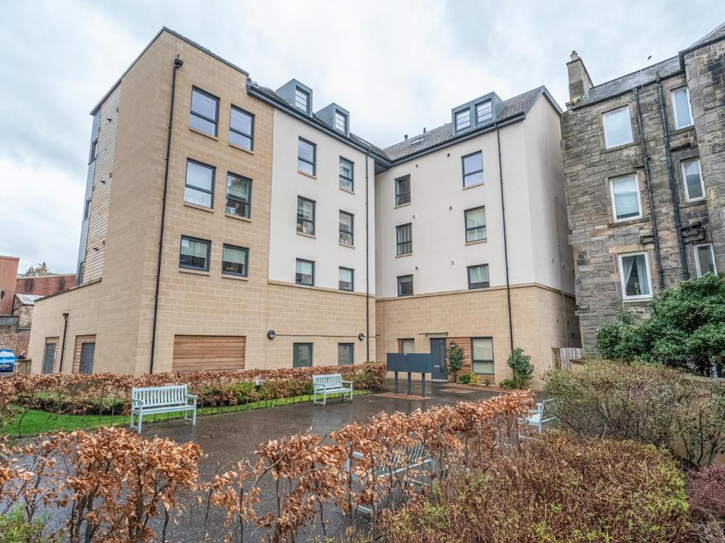 a building with two benches in front of it at Cosy Modern Flat Pass The Keys in Edinburgh