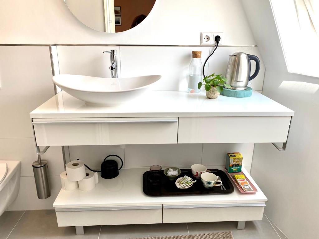 a white bathroom with a sink and a plate of food at Tiziana's Herberg in Zierikzee