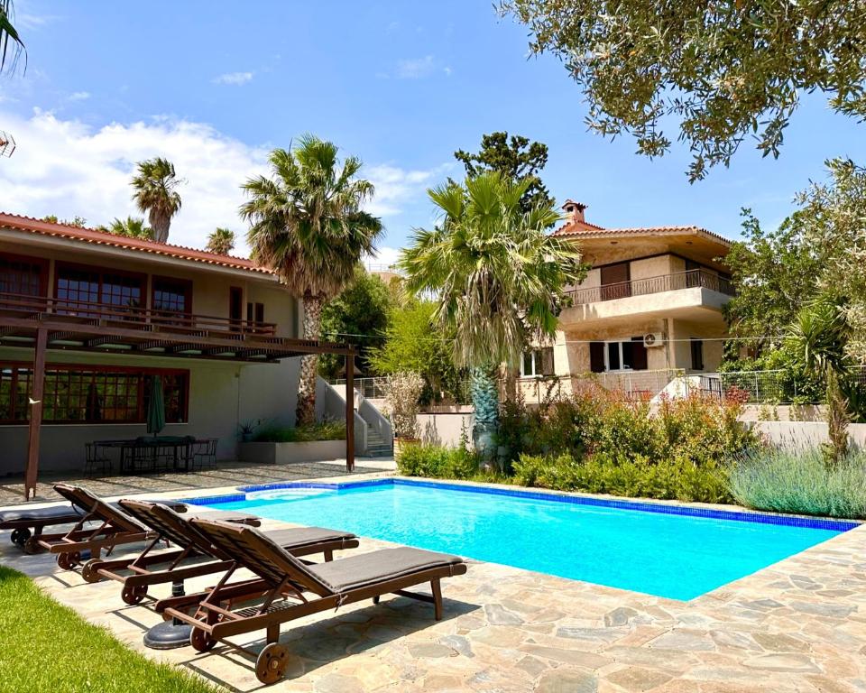 eine Villa mit einem Pool und einem Haus in der Unterkunft George's gorgeous house Anavysos in Anavyssos