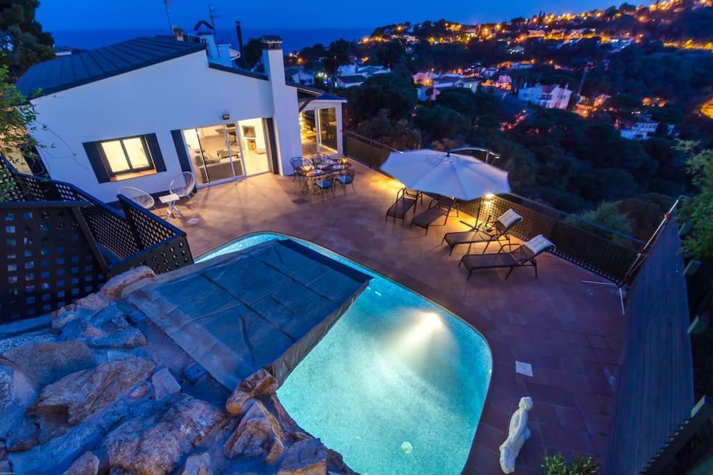 a backyard with a swimming pool and a house at Villa Luxury piscina y cascada 2 min de la playa in Lloret de Mar