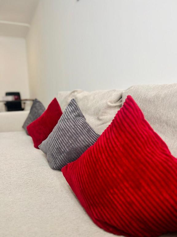 a group of red and gray pillows on a bed at Neuwertiges Apartment mit schnellem WLAN, Glasfaser, Kostenlose Privatparkplatz auch für Transporter geeignet R20 in Freiberg am Neckar