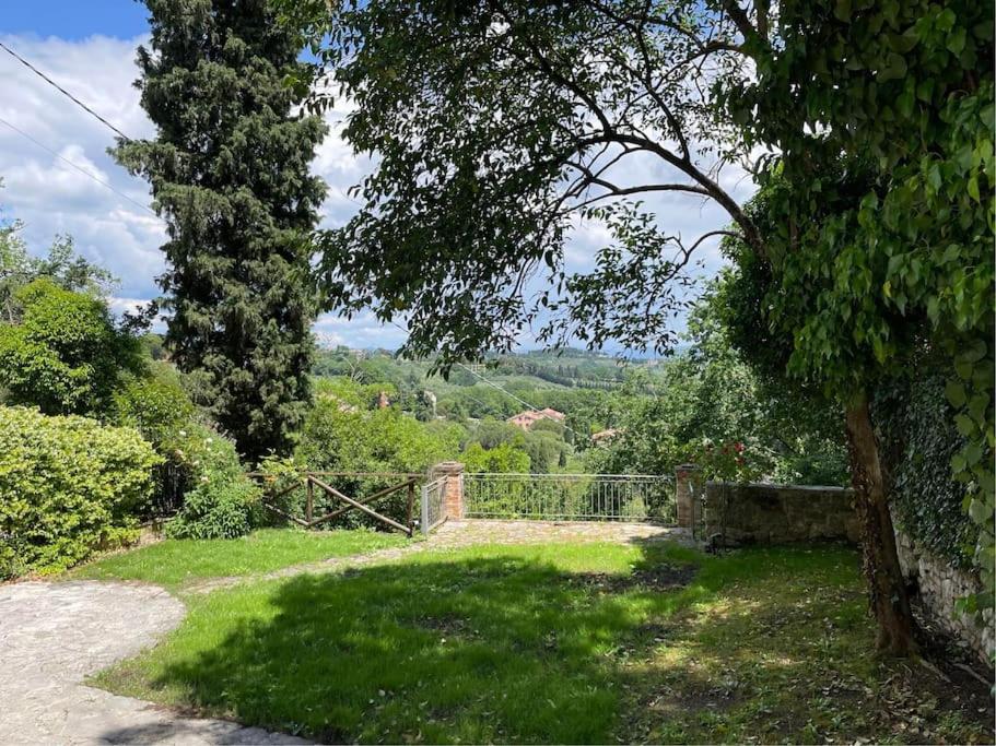 un jardín con una valla y un árbol y césped en Belvedere, en Perugia