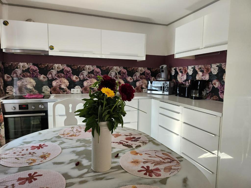 una cocina con una mesa con un jarrón de flores. en Ferienhaus Ani, en Patzig