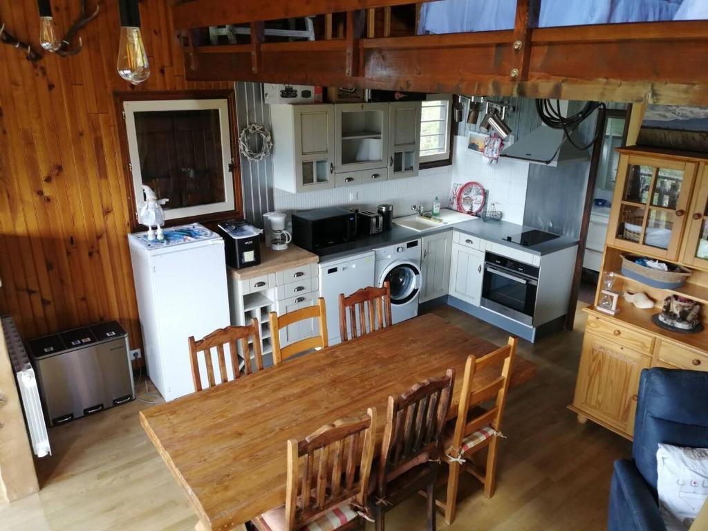een keuken met een houten tafel en een eetkamer bij haut de chalet le Bois de Cerf in Les Angles